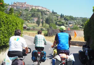 Cyclistes chargés et village à vue
